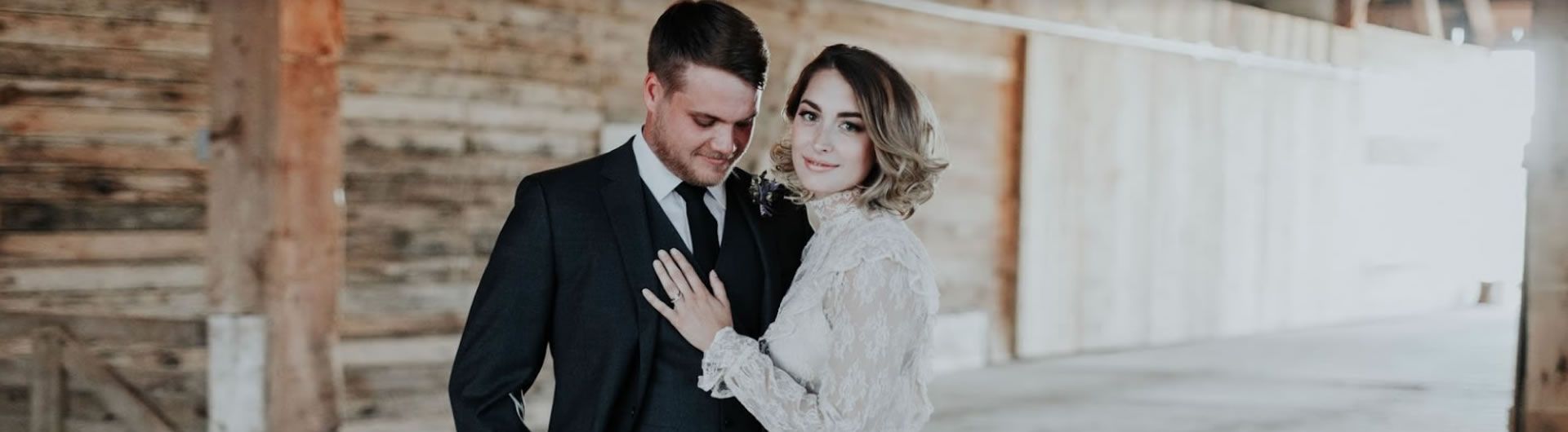 couple with barn wall backdrop